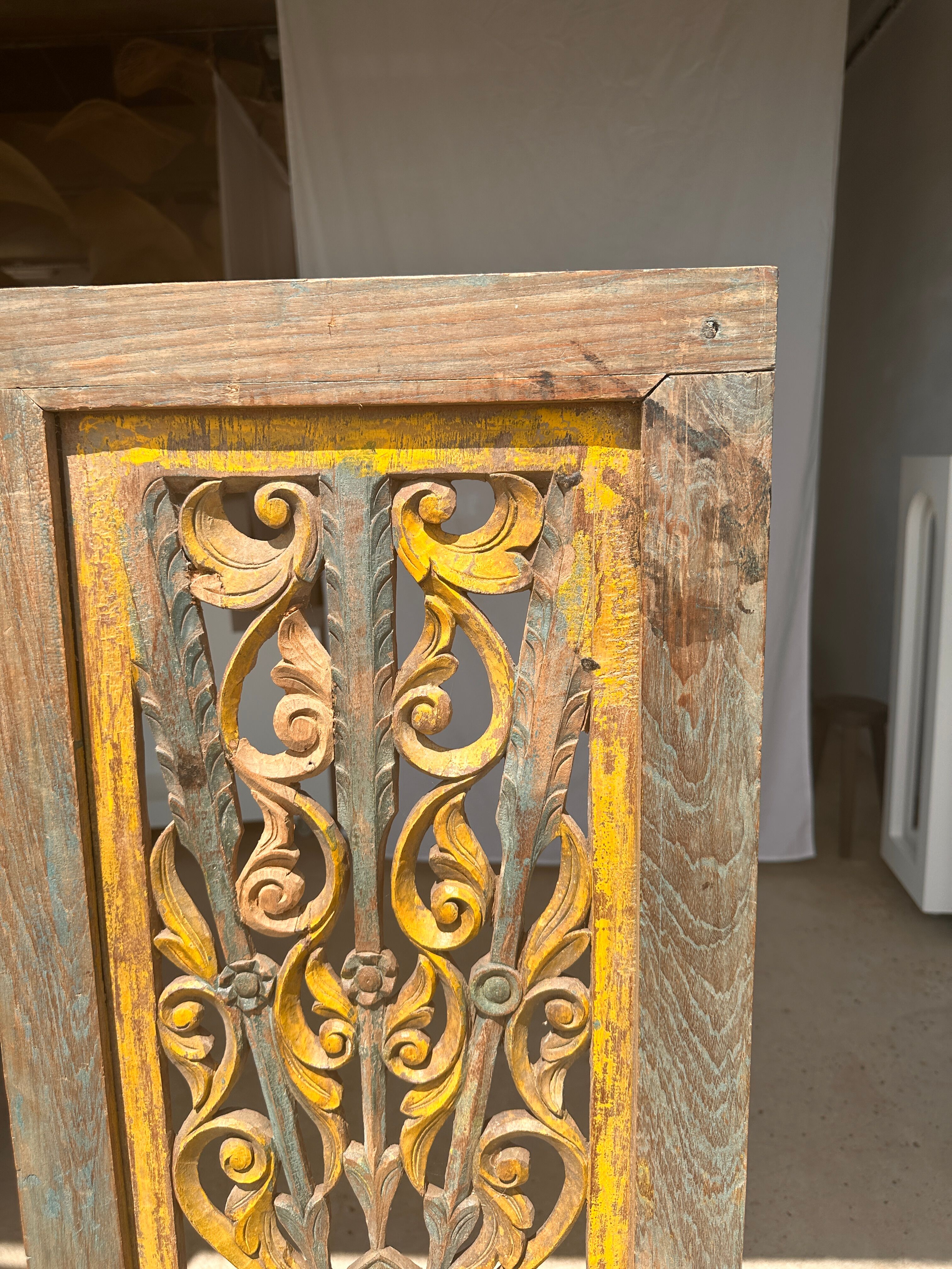 Rectangular Indonesian construction element with blue and yellow plant in carved wood