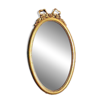Oval wall mirror. Louis XVI style. Pediment with ribbon bow/flowers. 41x23cm