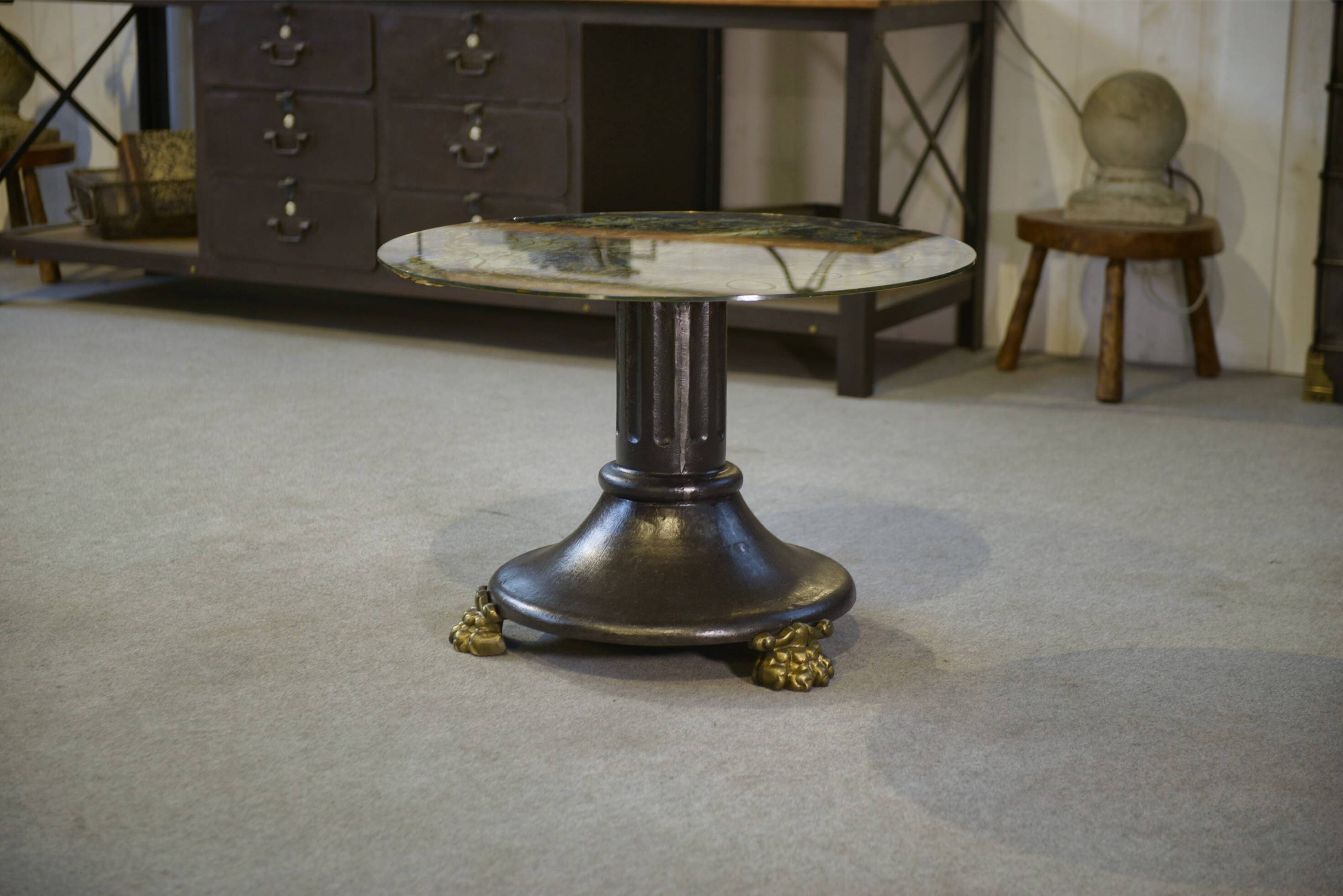 Neo-classical cast iron and glass eglomisé coffee table from the 1940s.