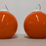 Pair of spherical pendant lights in orange opaline, France circa 1970.