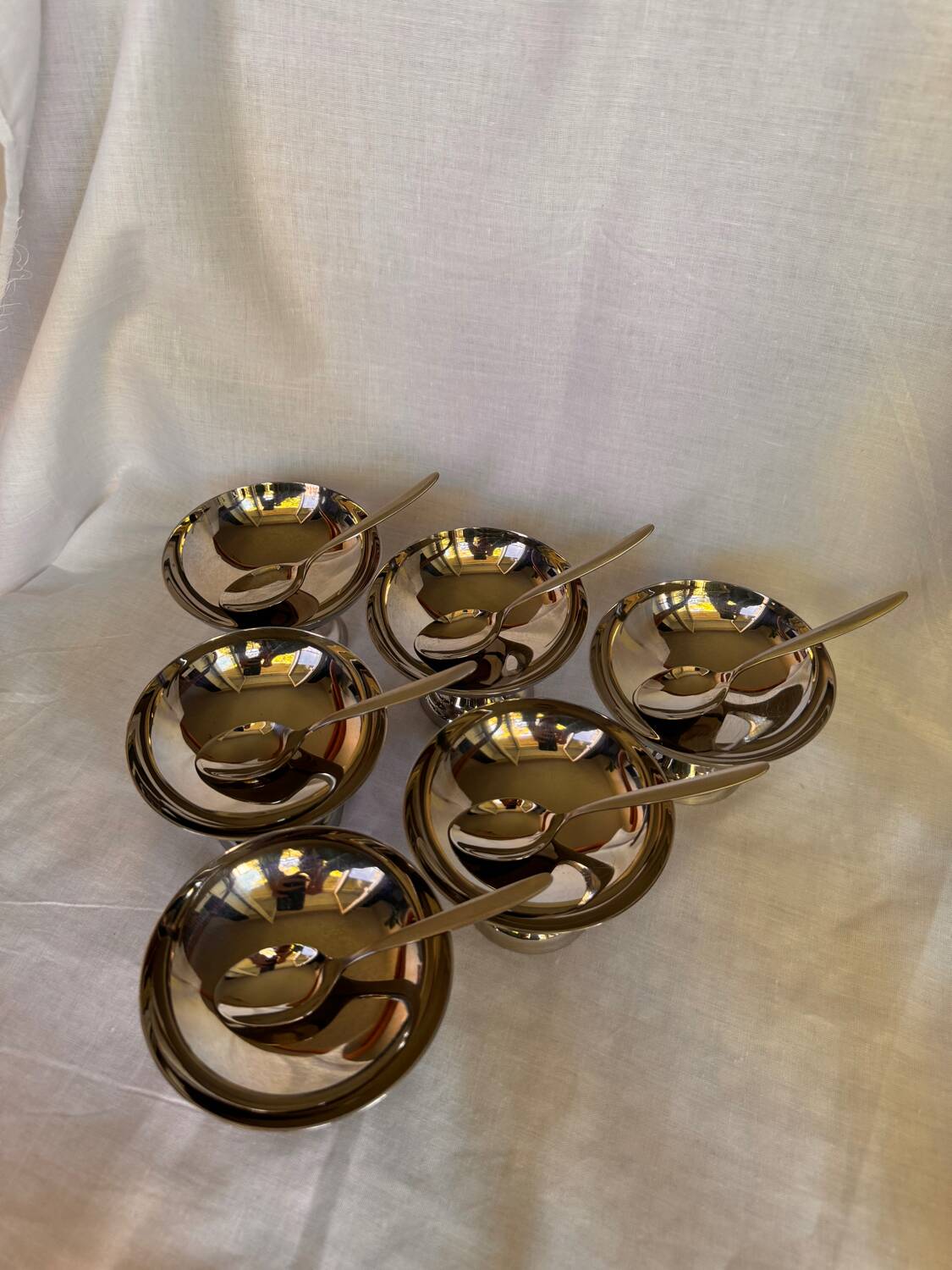 Set of 6 stainless steel ice cream bowls by Guy Degrenne with matching spoons.
