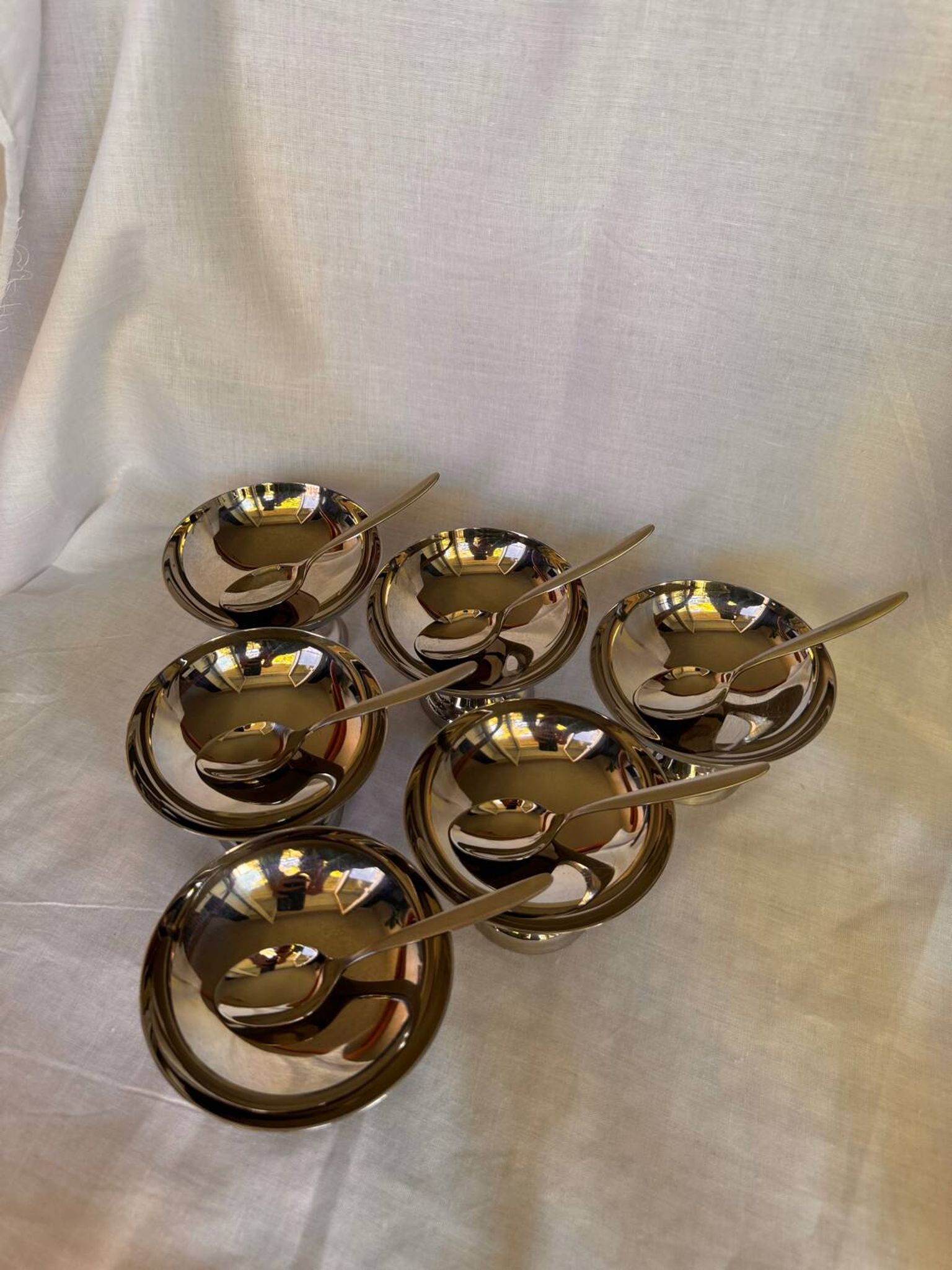 Set of 6 stainless steel ice cream bowls by Guy Degrenne with matching spoons.