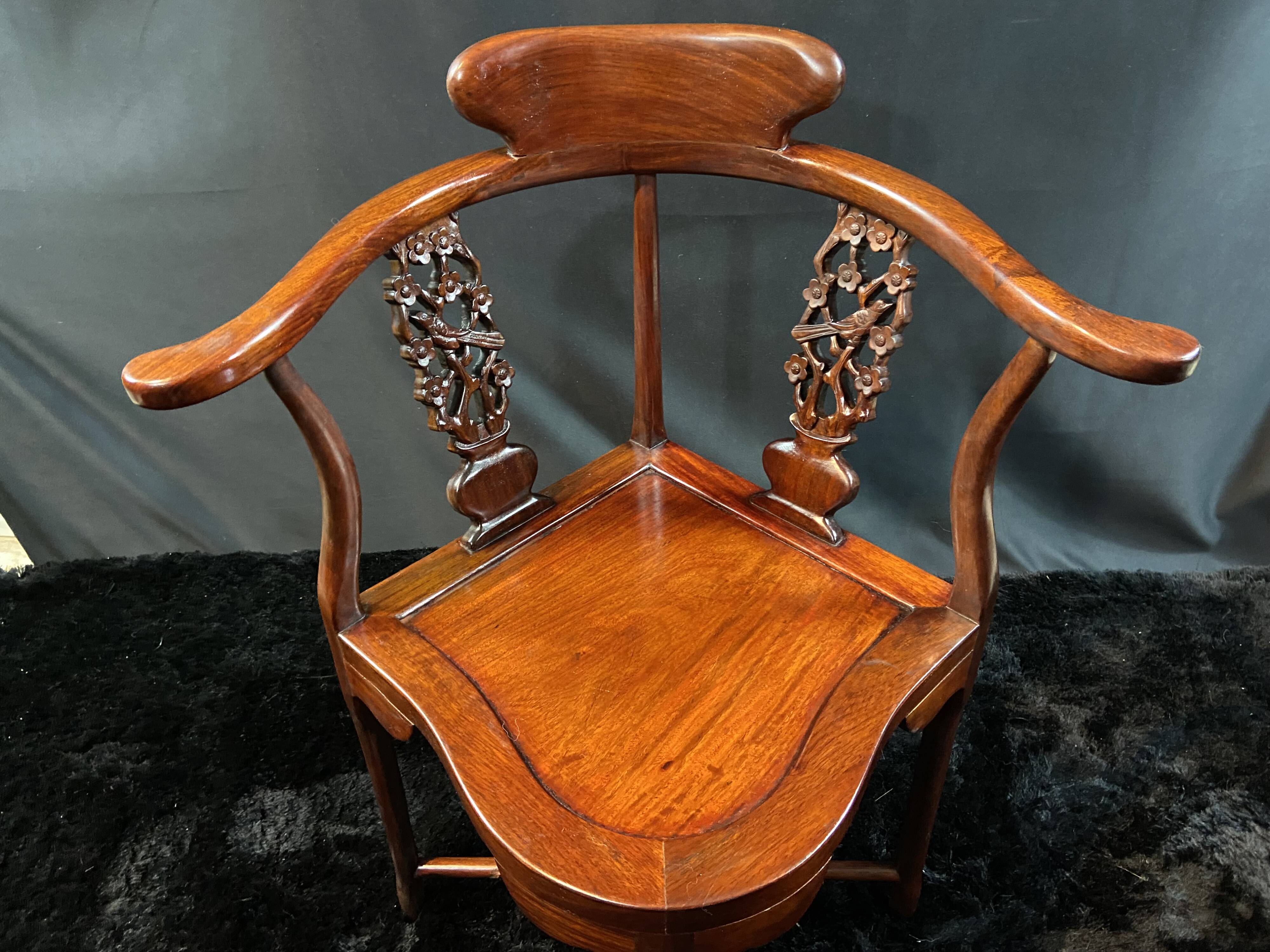 Corner armchair in solid wood with carved floral decoration featuring a bird.