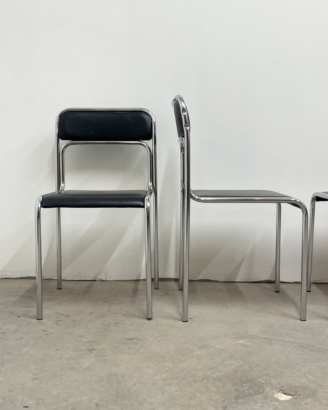 4 chrome metal chairs with black faux leather, 1990