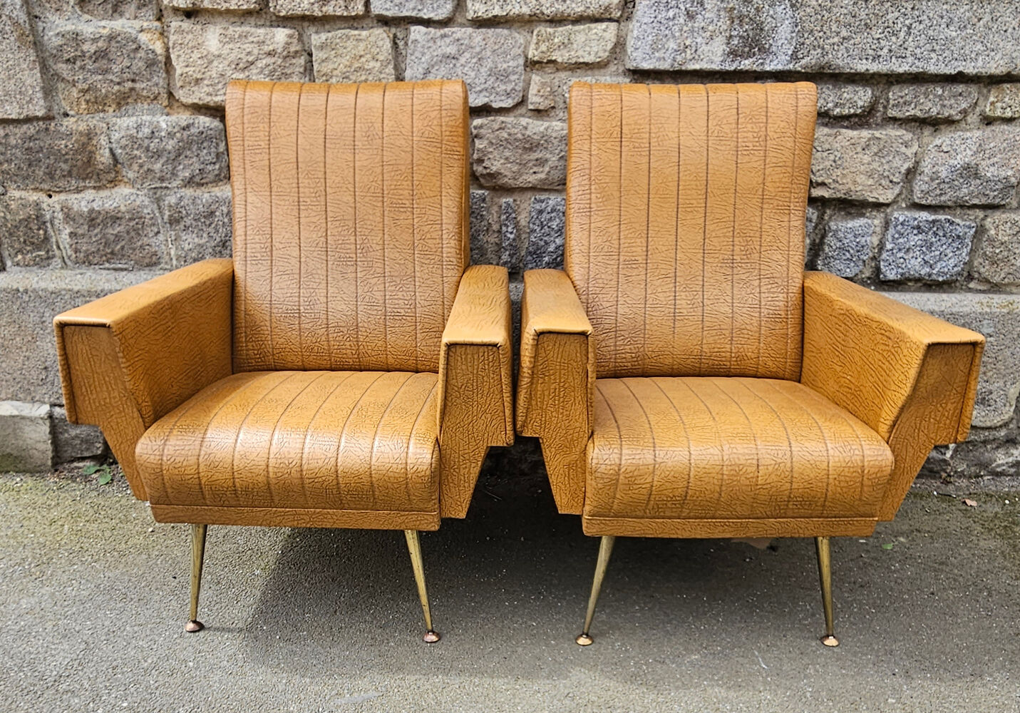 Pair of mustard skaï armchairs, brass feet