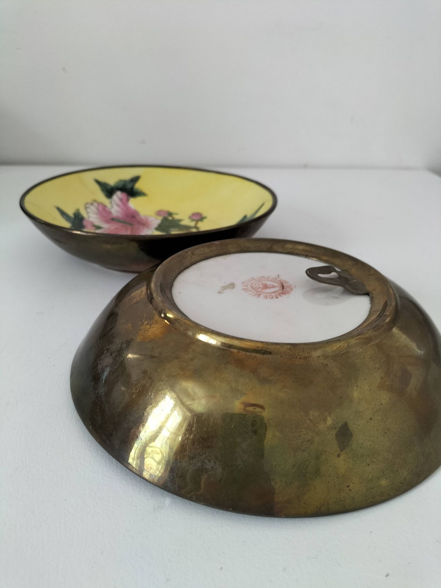 A pair of vintage Chinese decorative plates with floral designs on a yellow background.