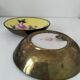 A pair of vintage Chinese decorative plates with floral designs on a yellow background.
