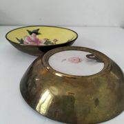 A pair of vintage Chinese decorative plates with floral designs on a yellow background.