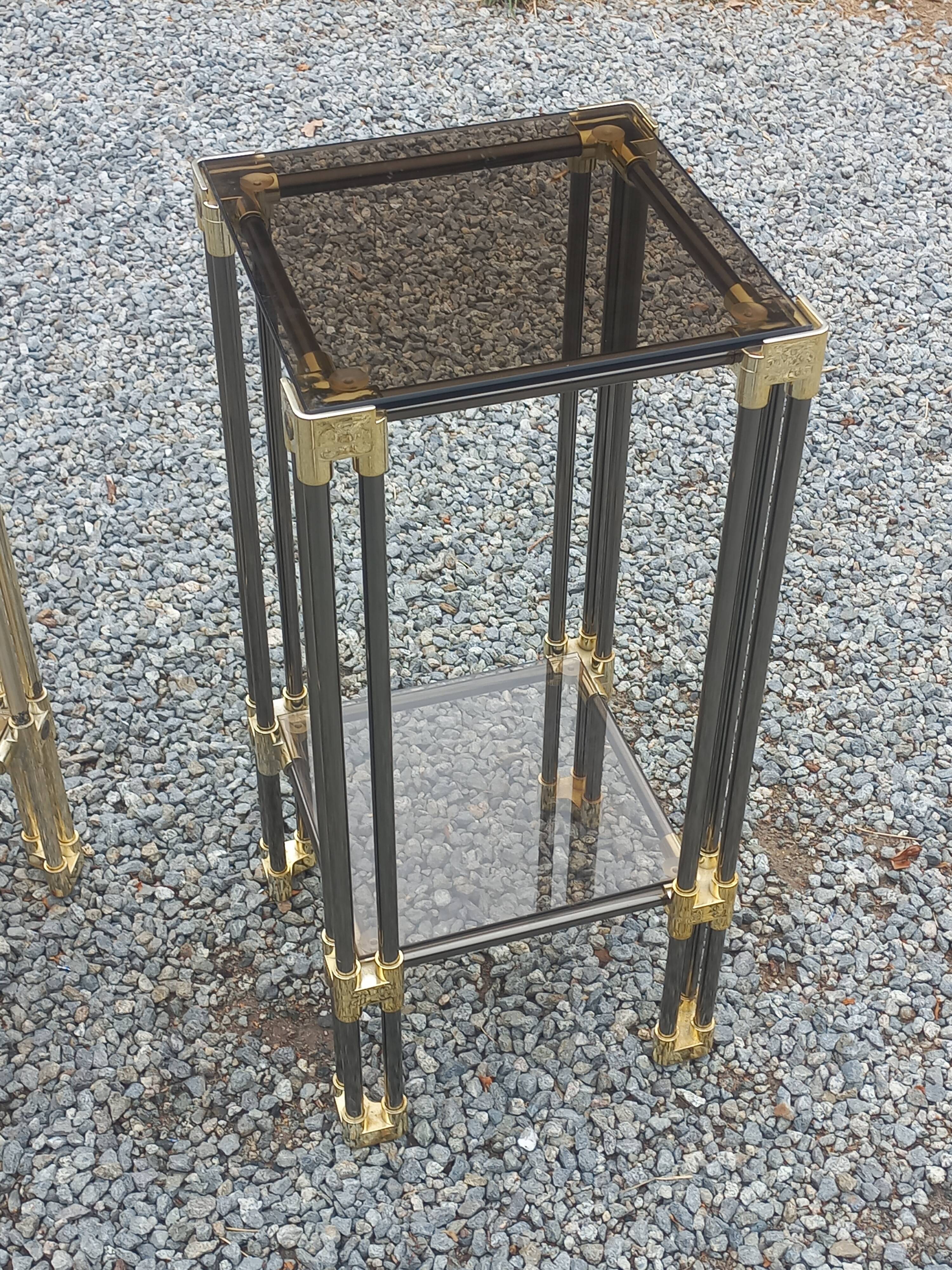 Pair of Hollywood Regency side tables in gold metal and smoked glass.
