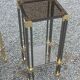 Pair of Hollywood Regency side tables in gold metal and smoked glass.