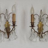 Pair of French antique brass double wall lights with assorted crystals.