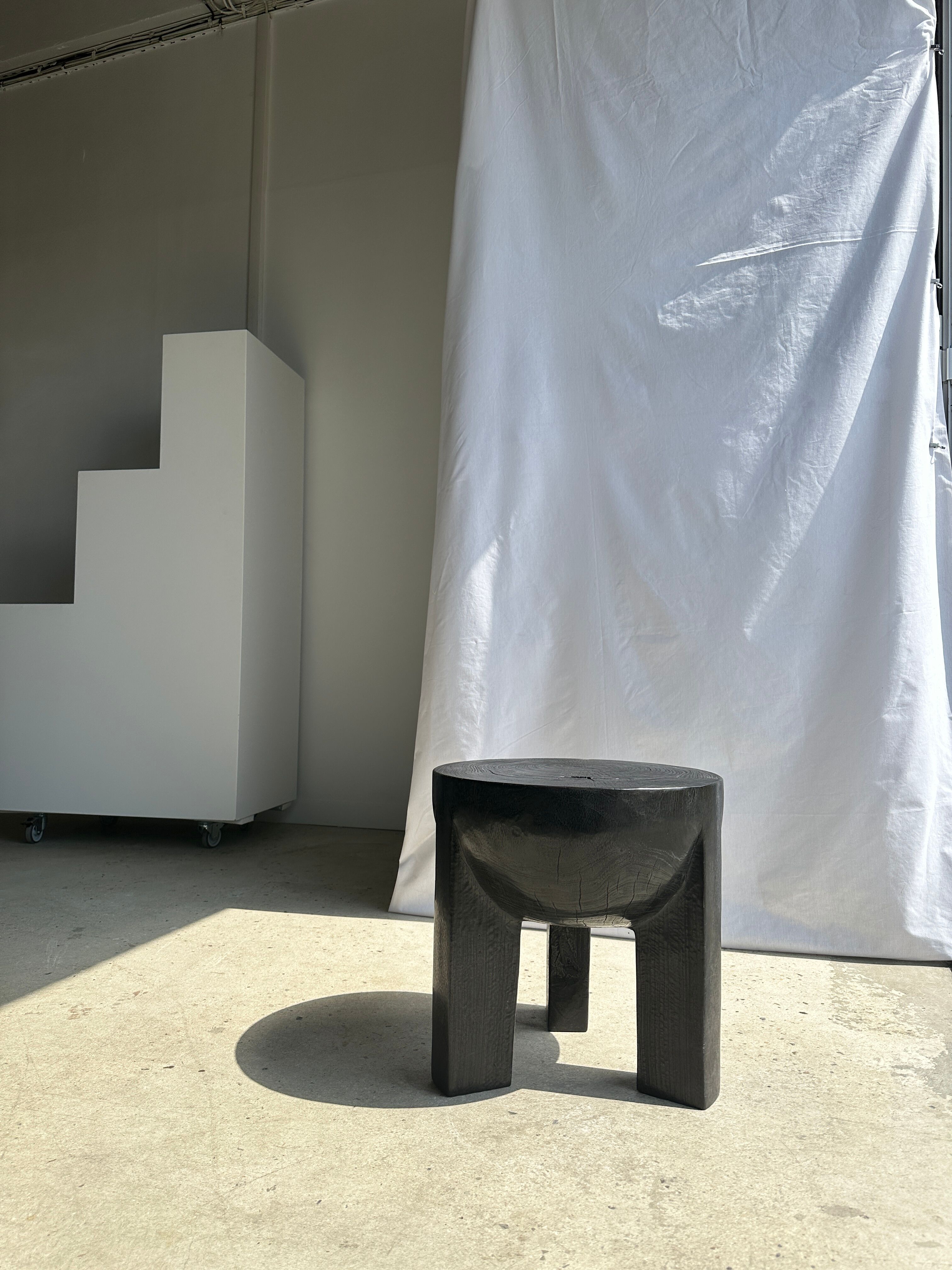 Black mango wood tripod side table with a semi-spherical top, height: 45 cm, diameter: 44 cm.