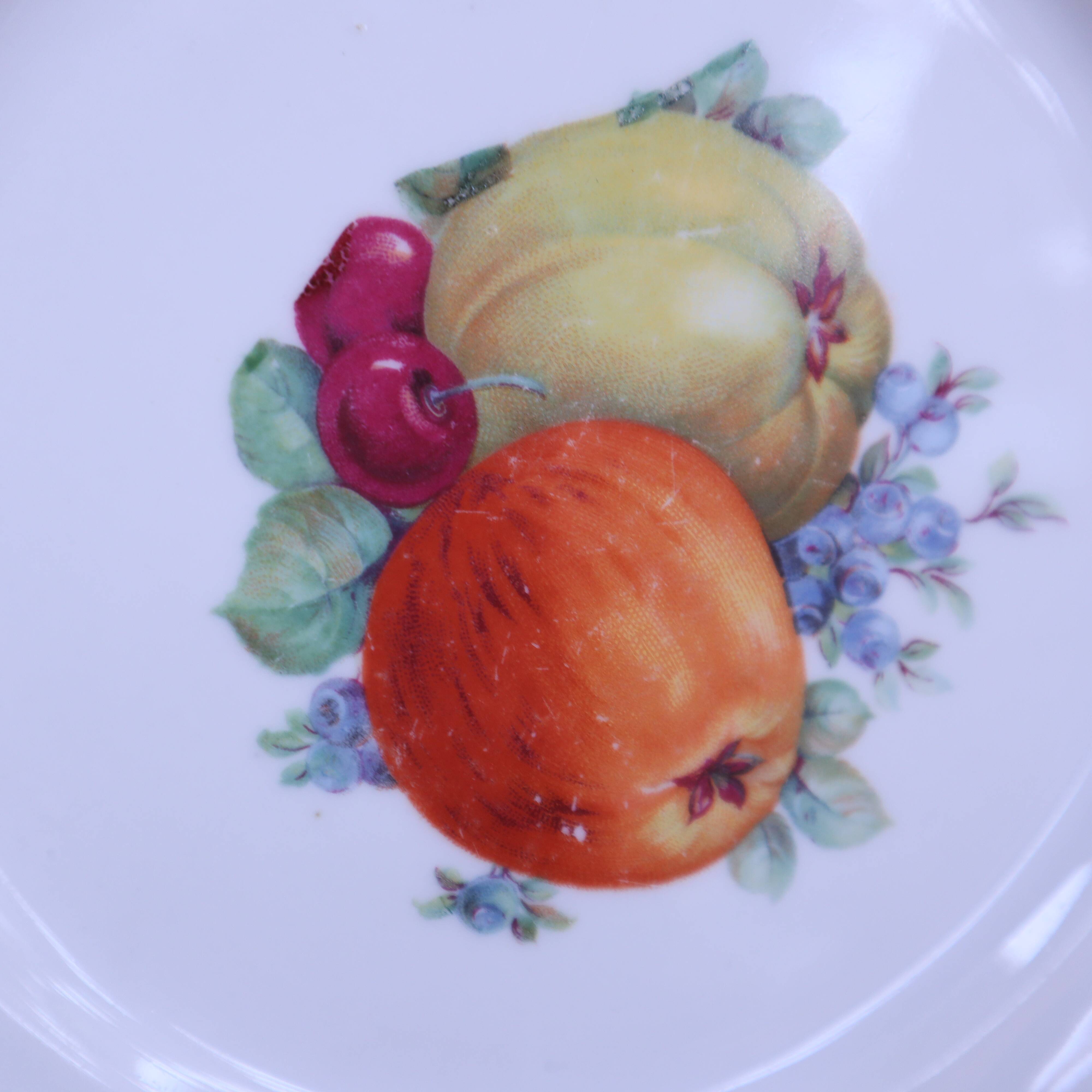 Set of 7 dessert plates and a cake stand with fruit patterns.