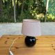 Vintage 80s table lamp with a black ceramic base and beige shade.
