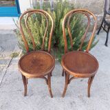 pair of round wooden chairs with a pattern on the seat