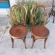 pair of round wooden chairs with a pattern on the seat
