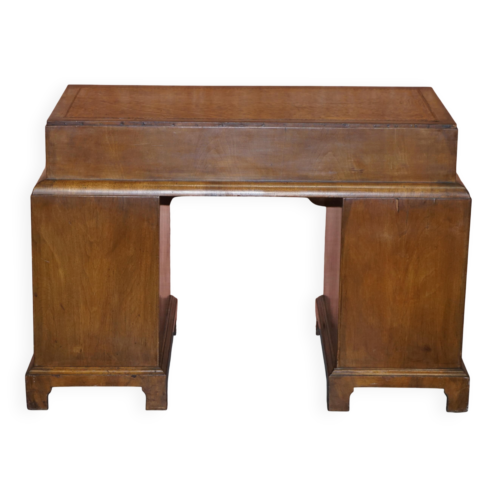 Curved pedestal desk in veined walnut, leather surface, late Victorian period.
