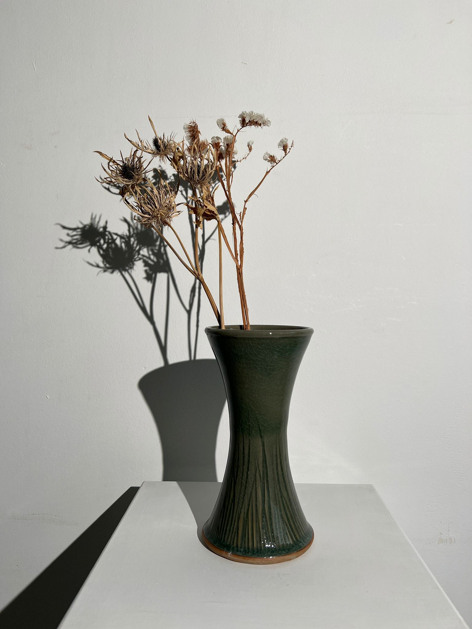 Dark green handcrafted vase with glazed ceramic grass blades