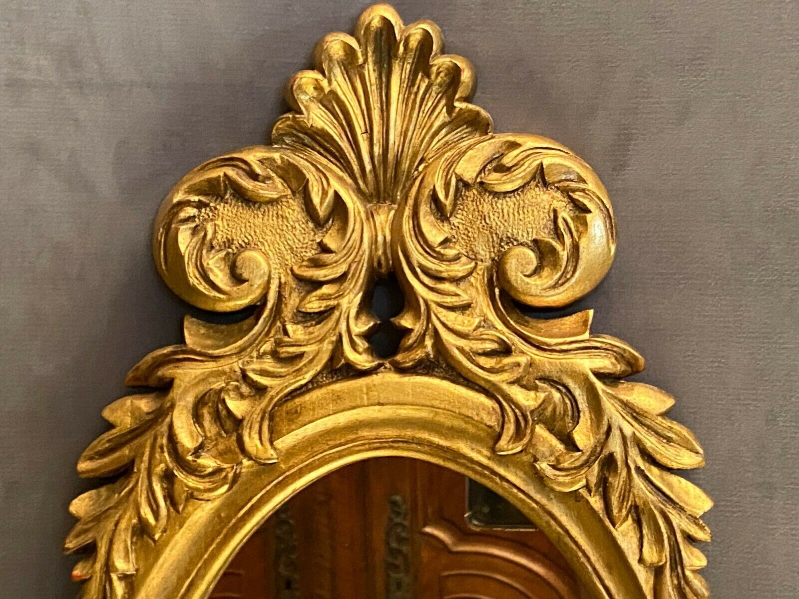 Oval view mirror in gilded wood with leafy decoration in Regency style