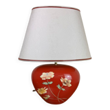 large vintage ceramic lamp with flower decorations on a red background circa 1980
