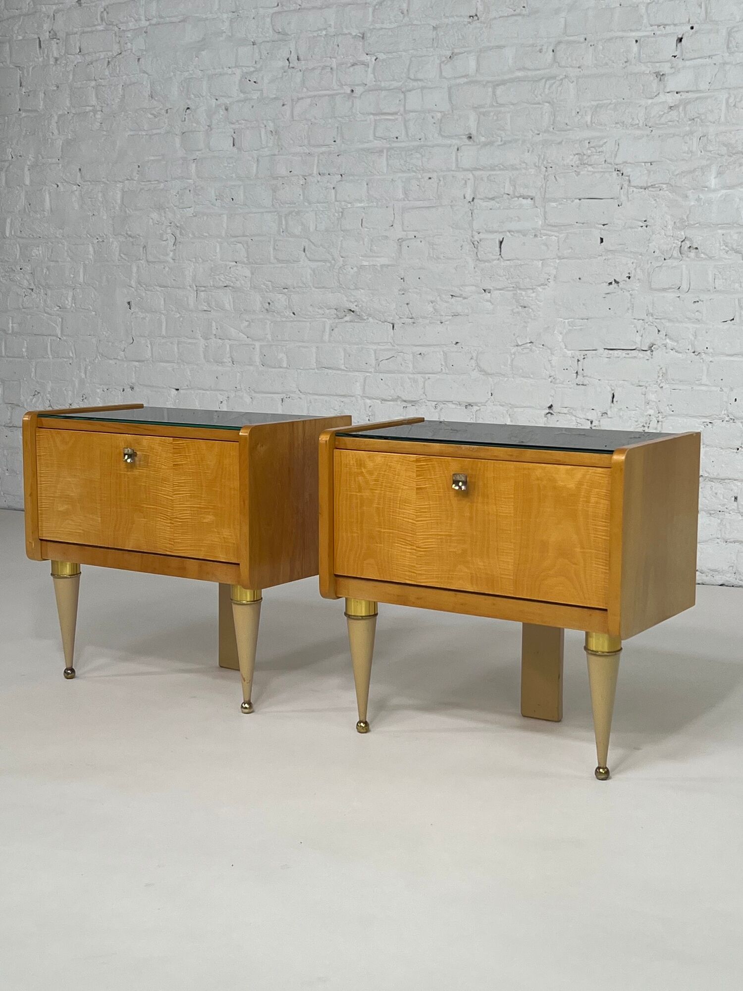 Pair of bedside tables in wood, brass and black glass top