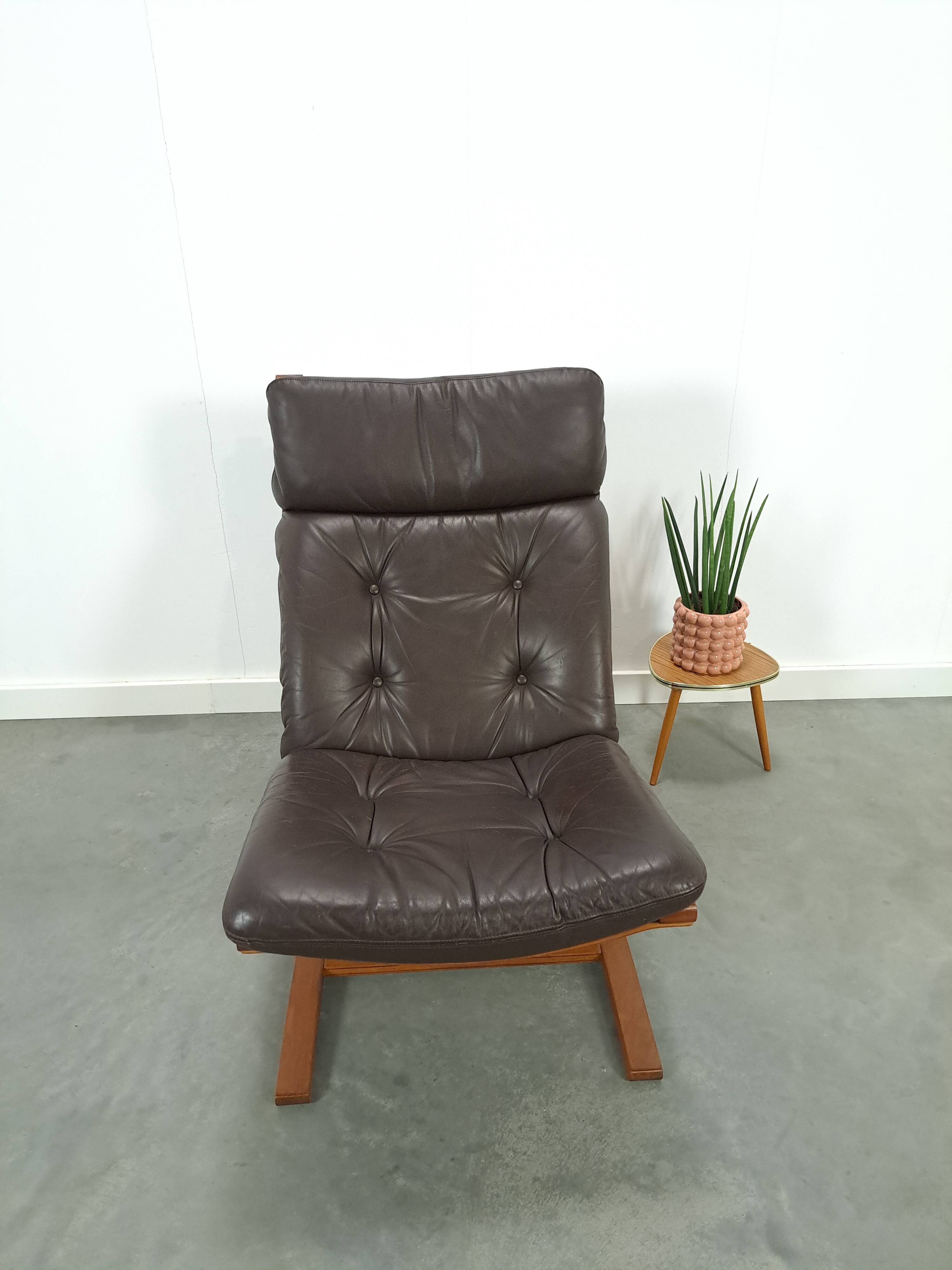 Bruin leren fauteuil met houten onderstel