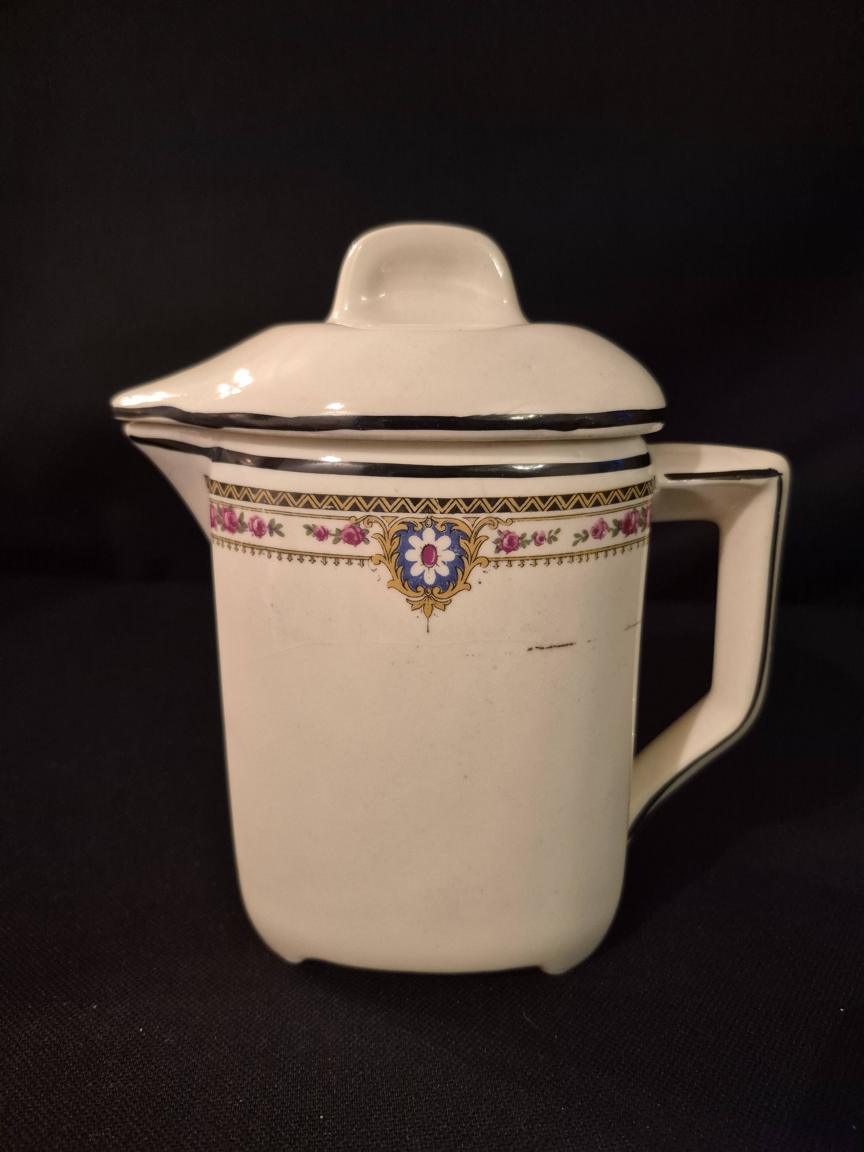 Old covered jug, vintage, geometric frieze with flowers and black trim.