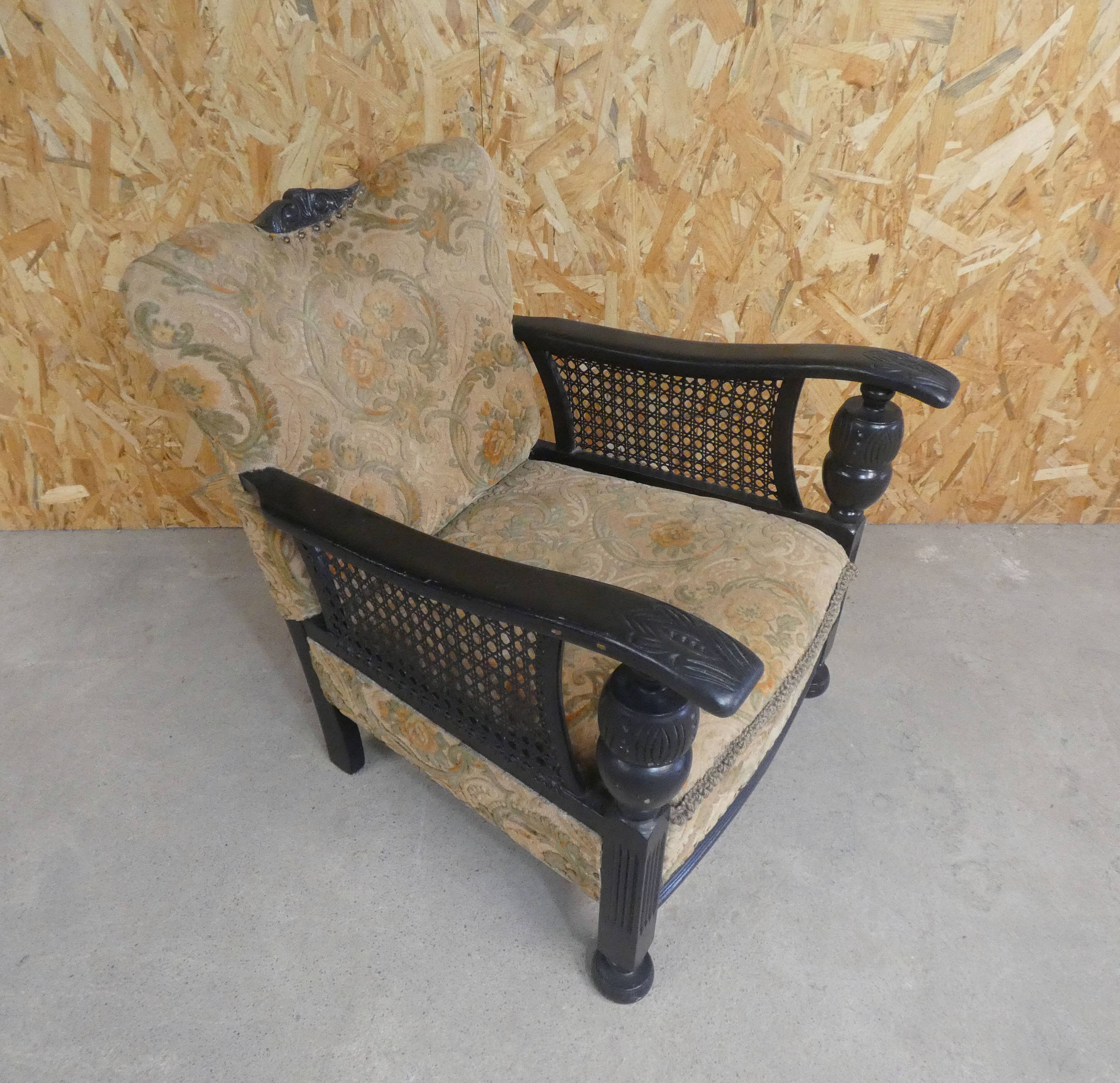 Old armchair upholstered in velvet, carved and caned wood