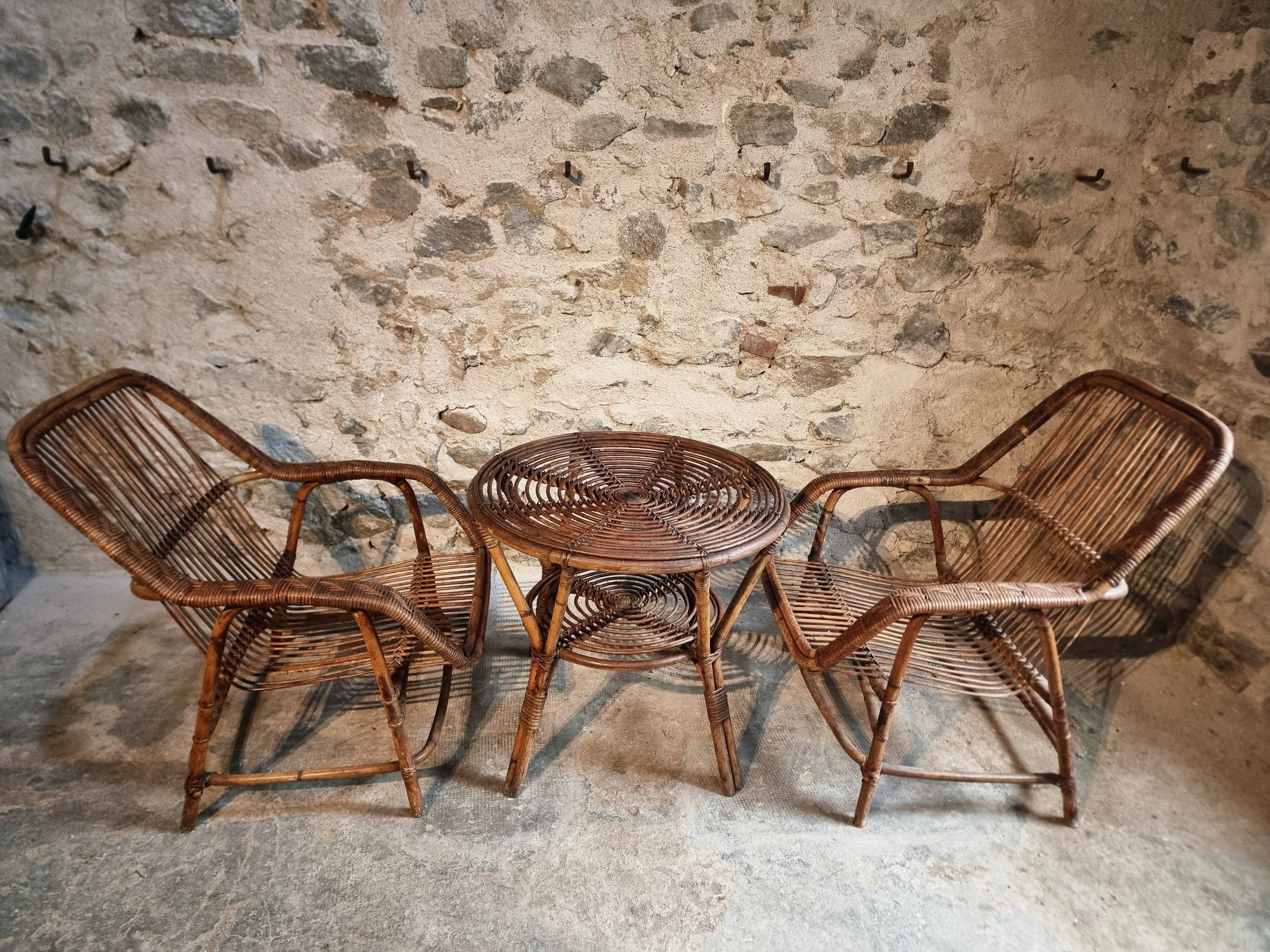 Vintage rattan lounge set, French wicker armchairs and round table, circa 1930–1950.