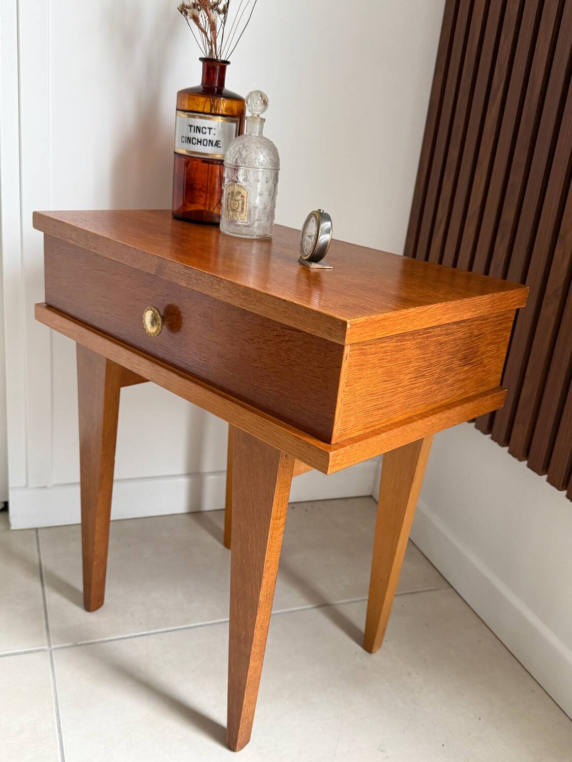 Vintage bedside table with tapered legs.