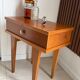 Vintage bedside table with tapered legs.