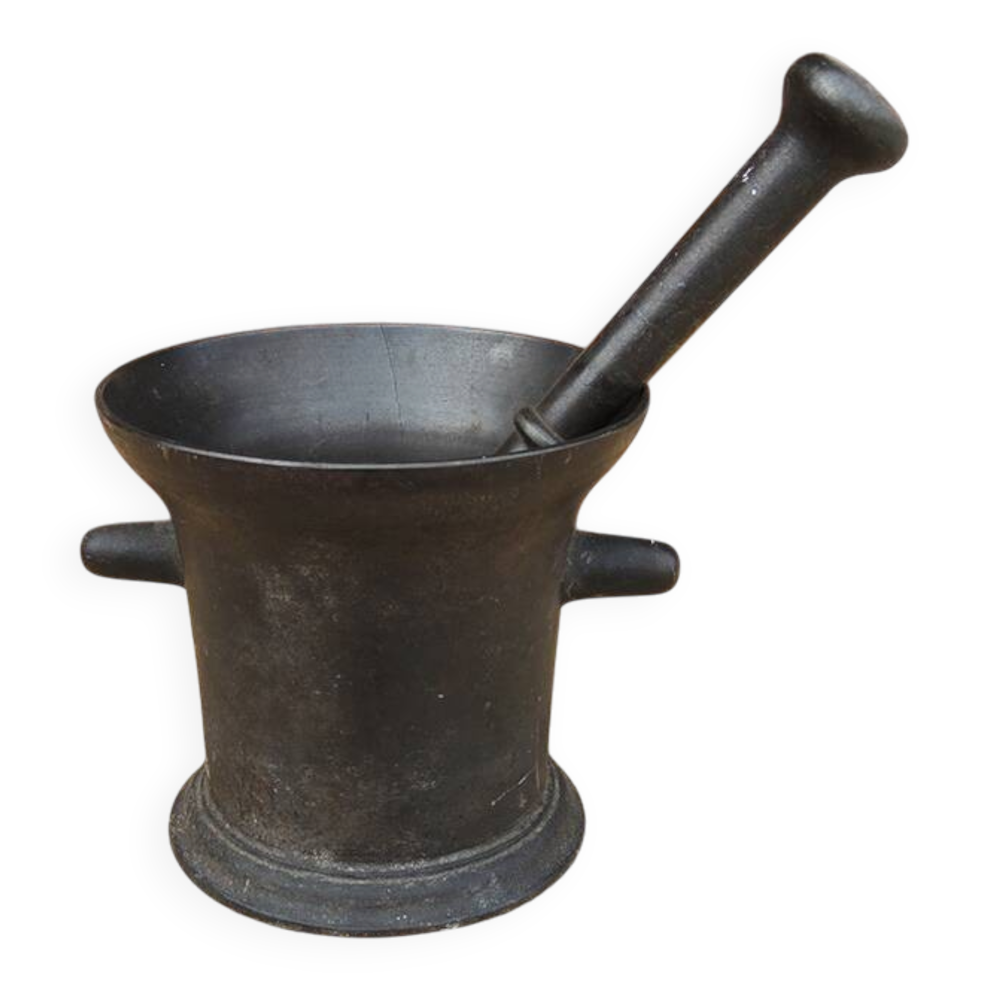 Ancient large mortar and pestle of a black cast iron apothecary.