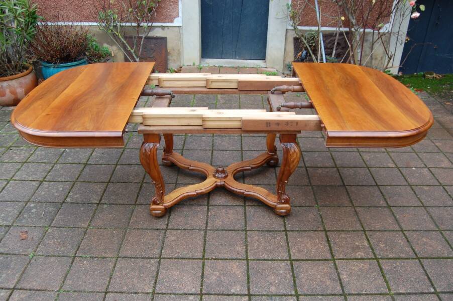 Napoleon III period walnut table from the late 19th century with extensions for 16 covers.