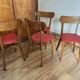 Set of 4 wooden chairs with red vinyl.