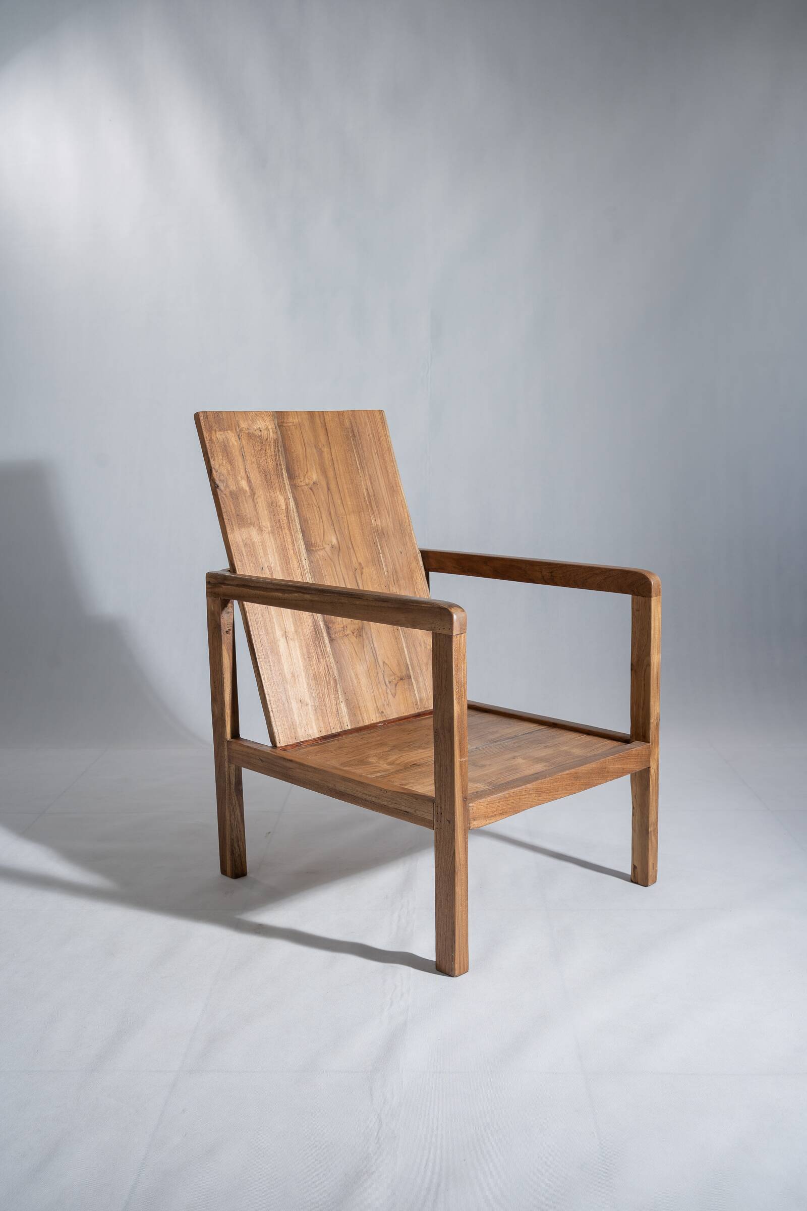 Large armchair in natural wood (teak) with a minimalist design.