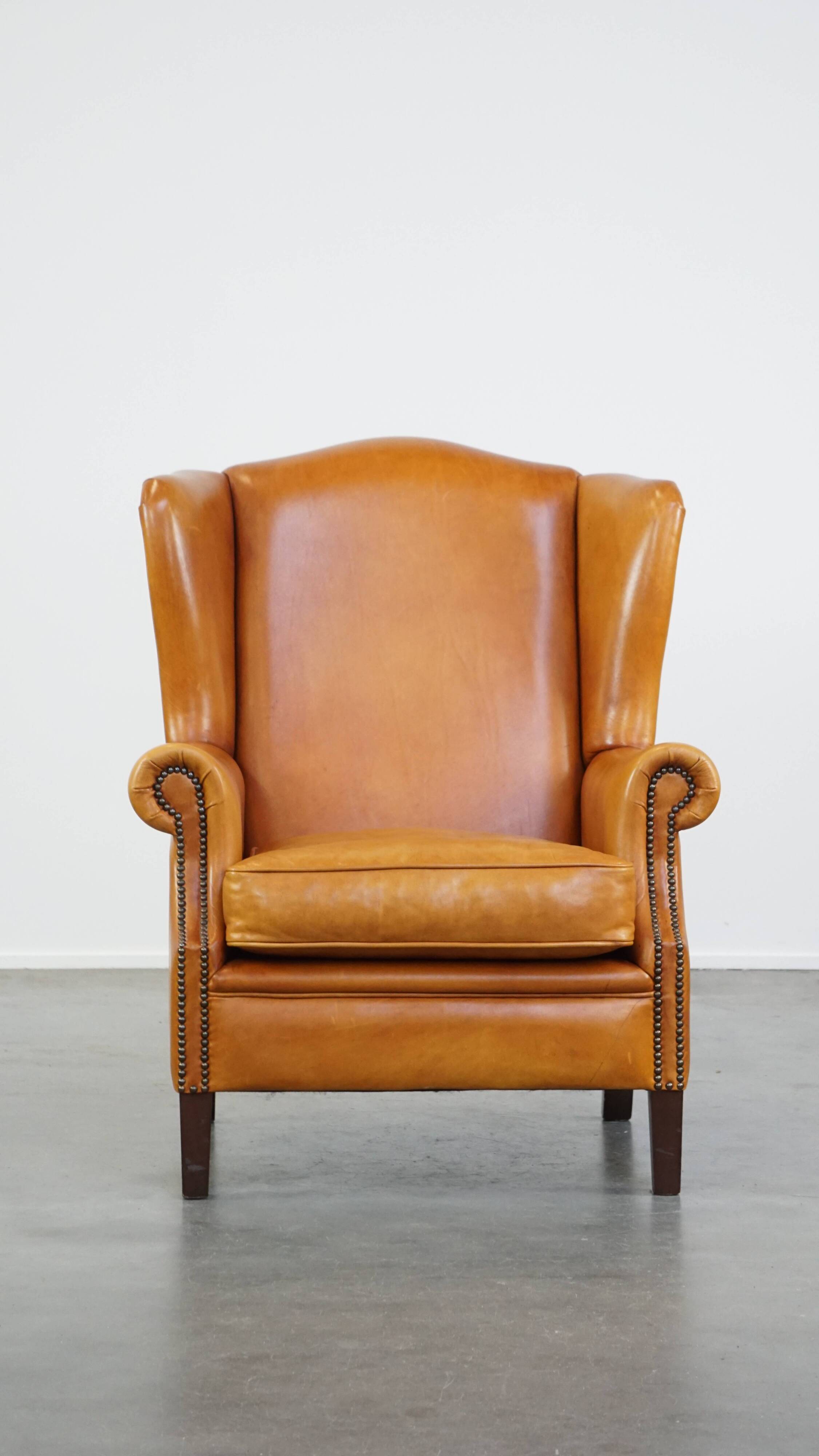 Cow leather wingback chair finished with decorative nails