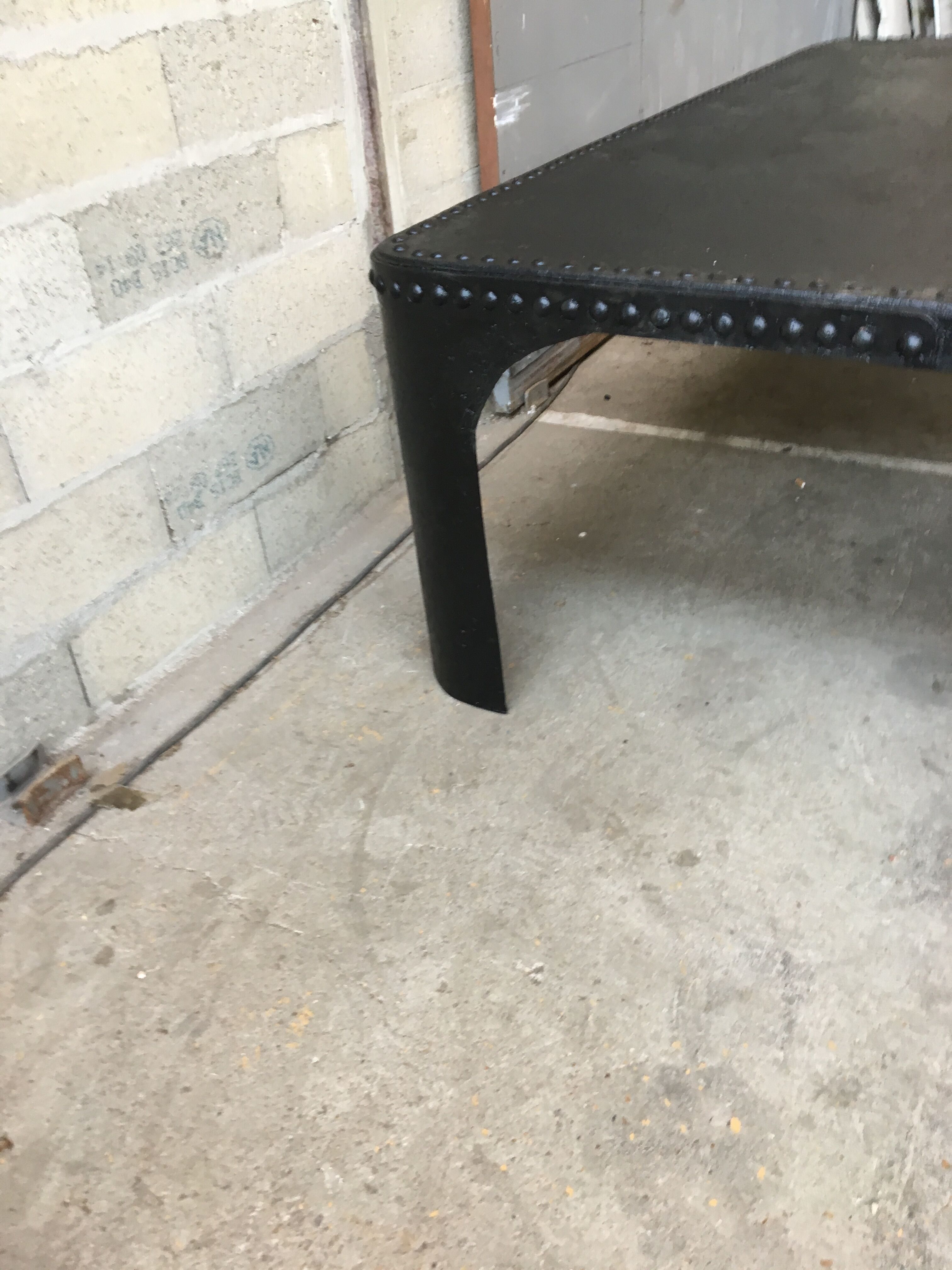 large industrial table in graphite black riveted metal