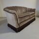 Vintage taupe two-seater canapé with fringes.