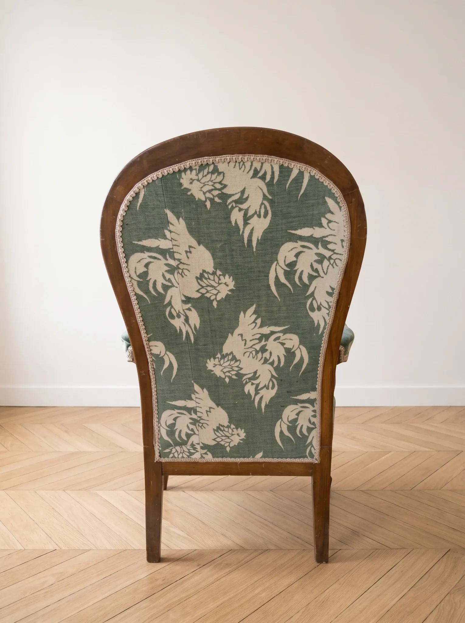 Antique Voltaire armchair in wood and green fabric with floral patterns.