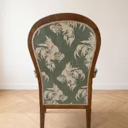 Antique Voltaire armchair in wood and green fabric with floral patterns.