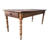 Antique farmhouse table in solid cherry wood with turned legs.