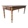 Antique farmhouse table in solid cherry wood with turned legs.