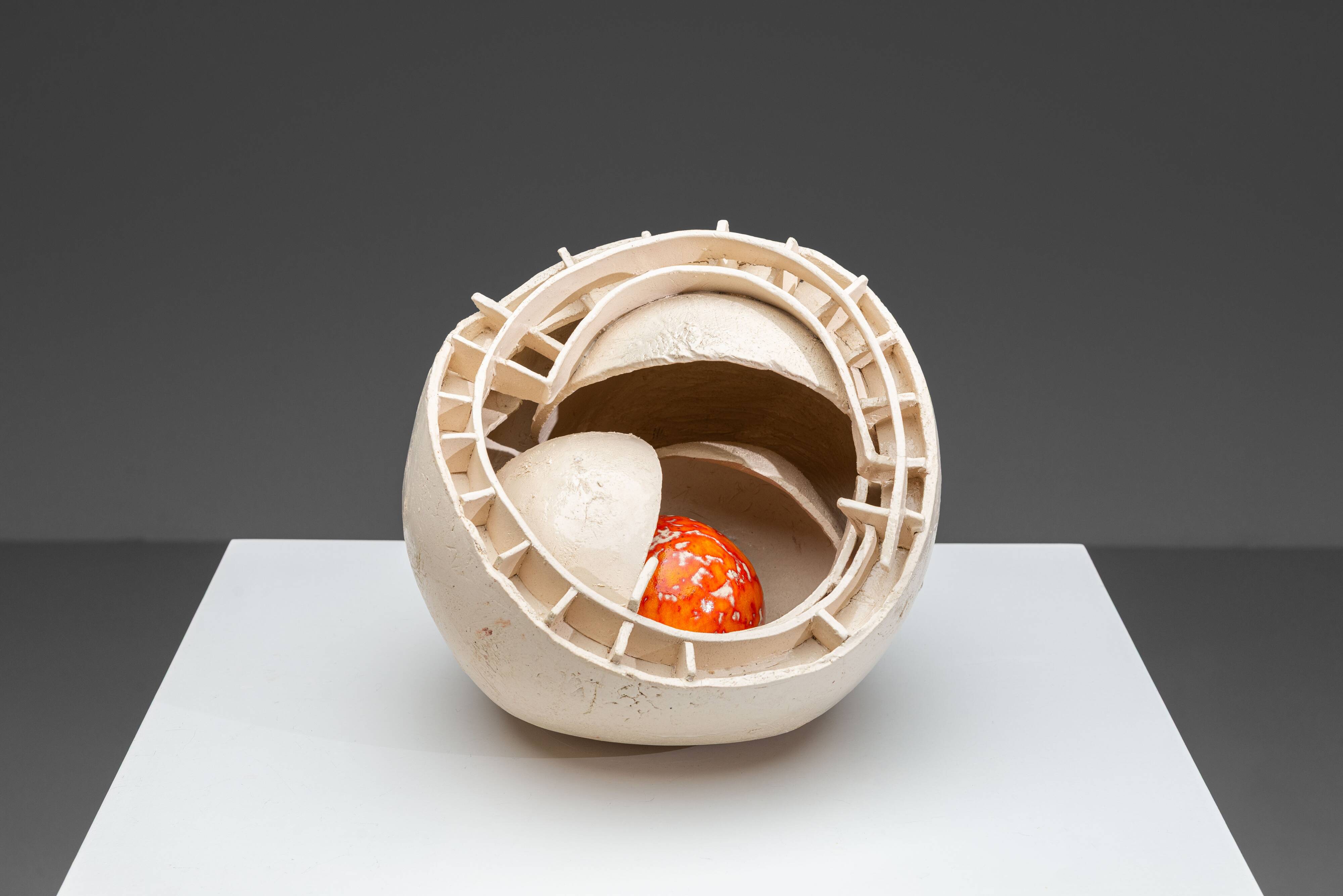 Sculpture en céramique abstraite avec un noyau orange.
