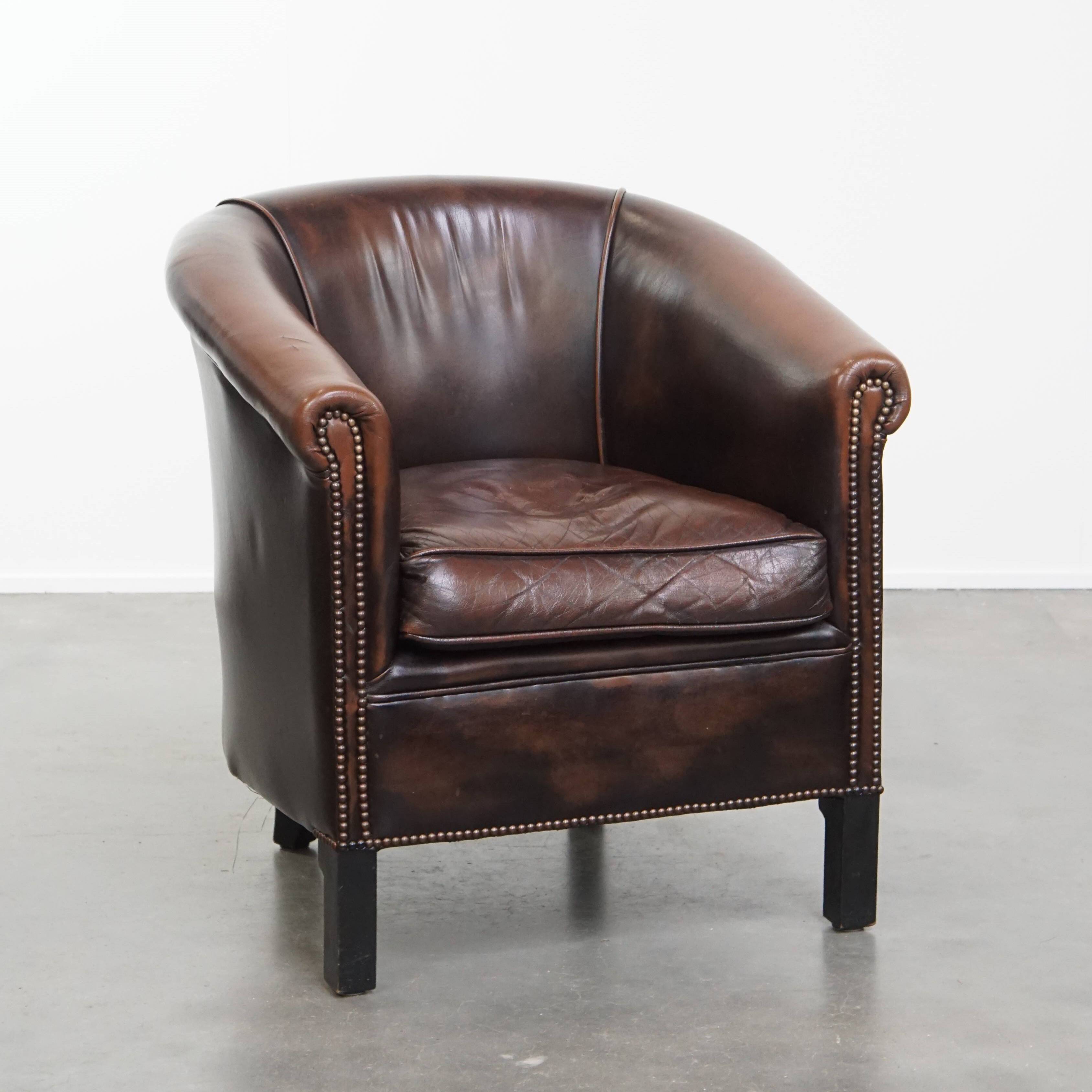 Fauteuil club de couleur foncée en cuir de vachette