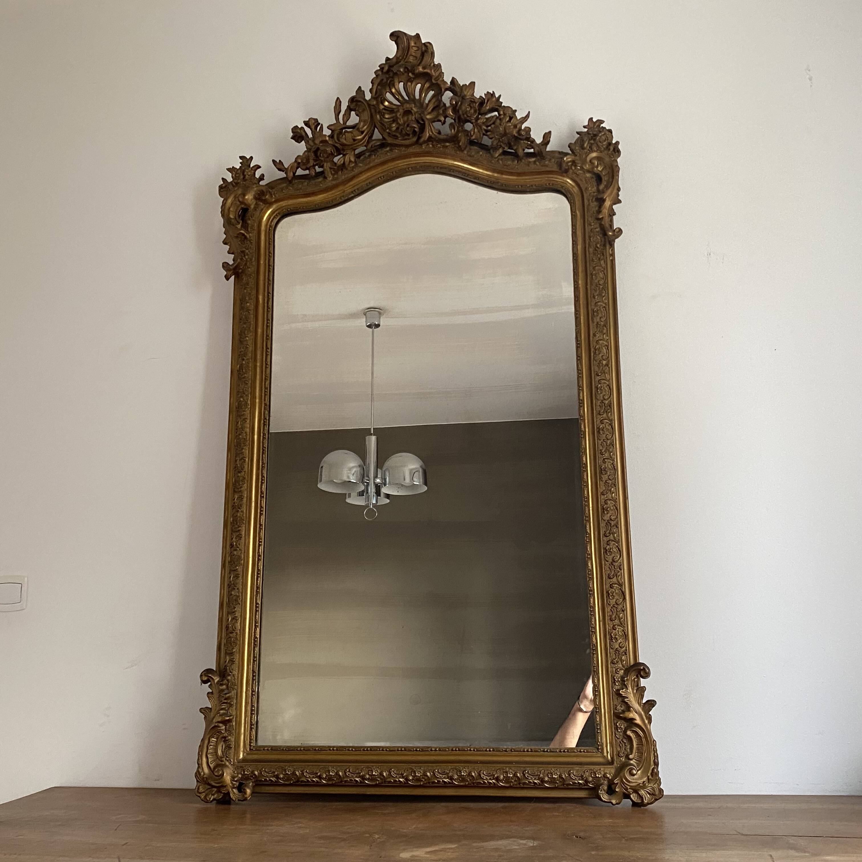 Late 19th century gilded mirror with decorated pediment. 155x88.