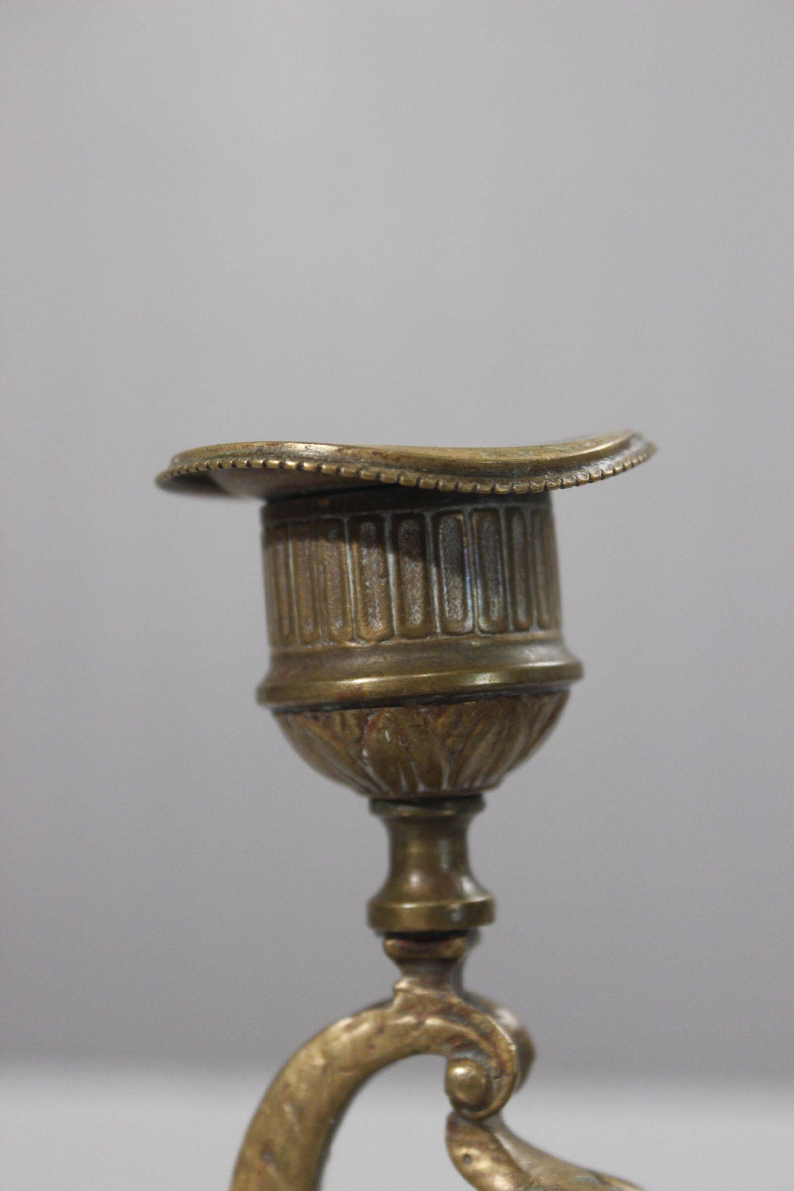 Handheld candlestick in bronze featuring a griffin, 19th-century Empire style.
