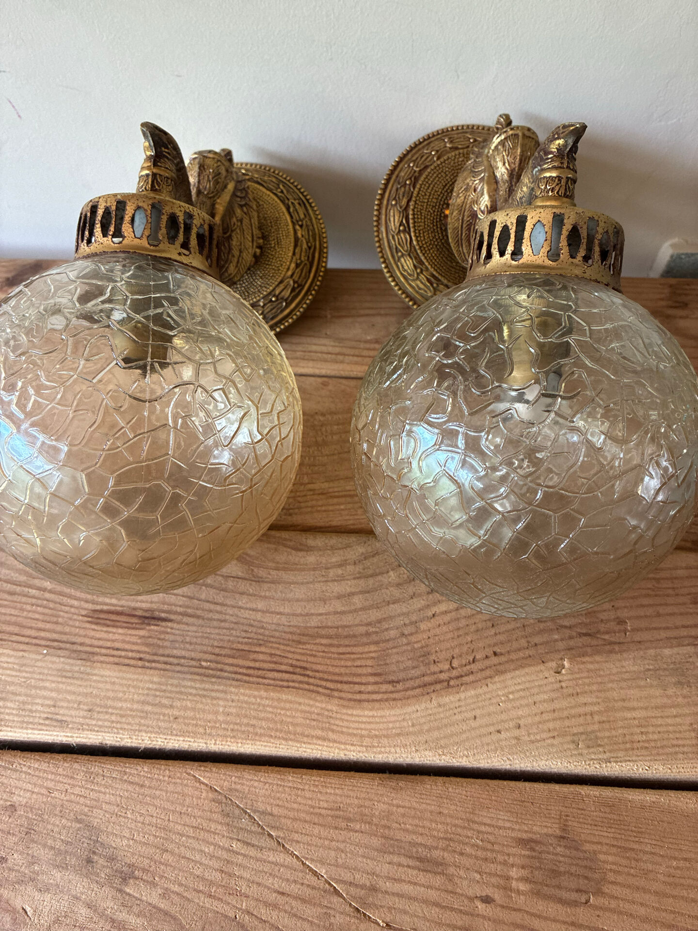 Pair of vintage wall sconces with golden metal swan heads and glass.