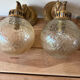 Pair of vintage wall sconces with golden metal swan heads and glass.