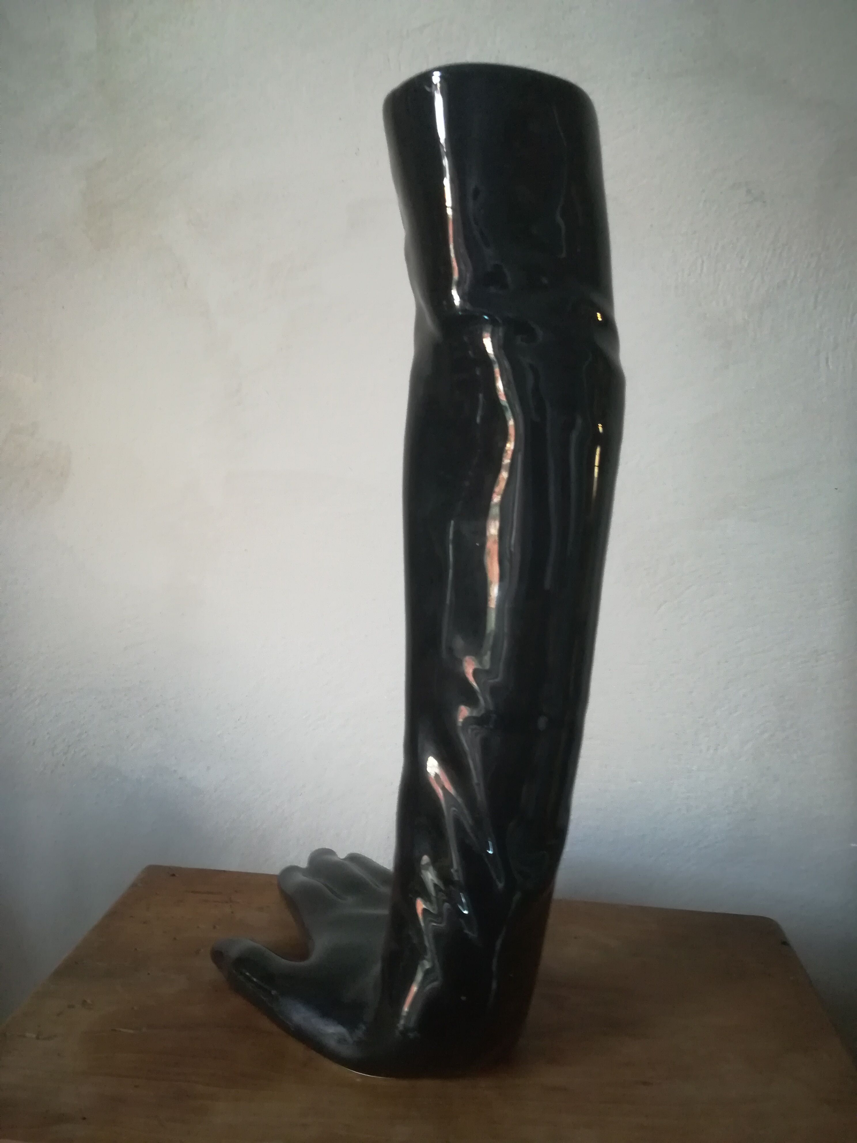 Black earthenware vase gloved hand