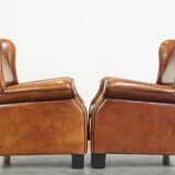 Set of 2 very comfortable large sheepskin armchairs elegantly finished with black piping